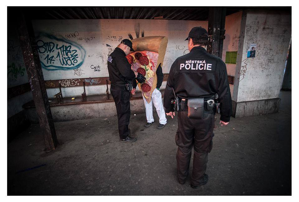 Městská policie pokutuje pizzu za poruseni zákazu kouření na zastávce v Praze na Smíchově.
